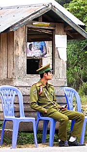 Army or Policeman watching the Traffic in Muang La by Asienreisender